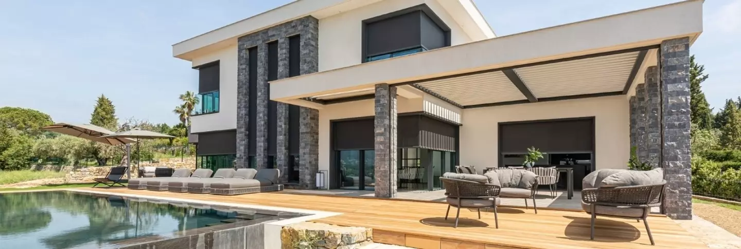 Screens en lamellendak beschutten zonovergoten villa